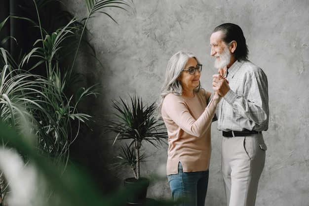 El amor nunca envejece. Alegre pareja romántica jubilada activa bailando en la sala de estar.