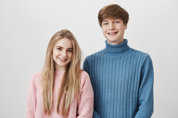 Amor, relaciones, romance y felicidad. Hermosa joven pareja posando contra el espacio gris