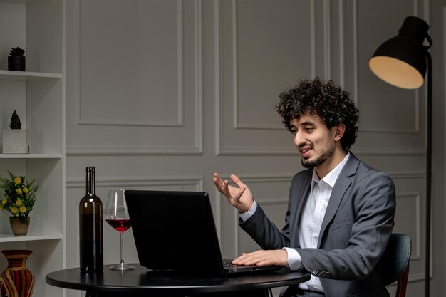 Amor virtual guapo chico lindo en traje con vino en una cita de computadora a distancia hablando en cámara