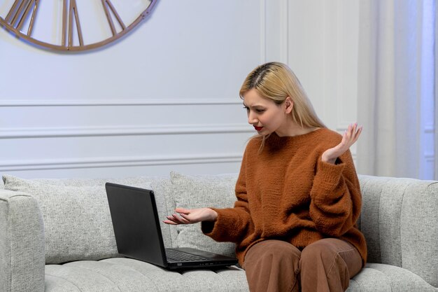 Amor virtual linda jovencita rubia en suéter acogedor en fecha de computadora a distancia agitando las manos