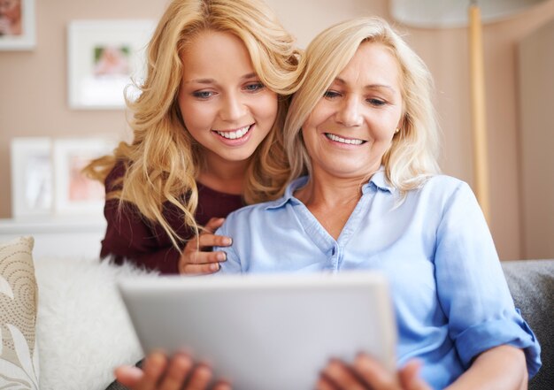 Amorosa madre e hija disfrutando de internet inalámbrico