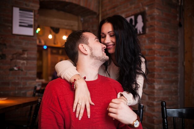 Amorosa mujer abrazando al hombre en el café