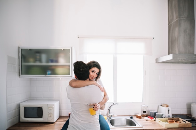 Amorosa pareja abrazándose en la cocina