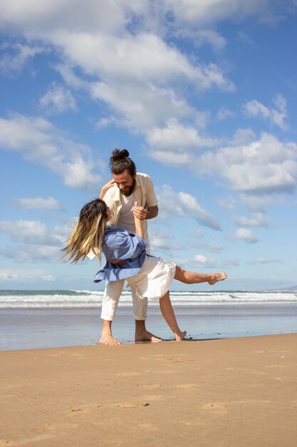 Amorosa pareja caucásica bailando en la playa