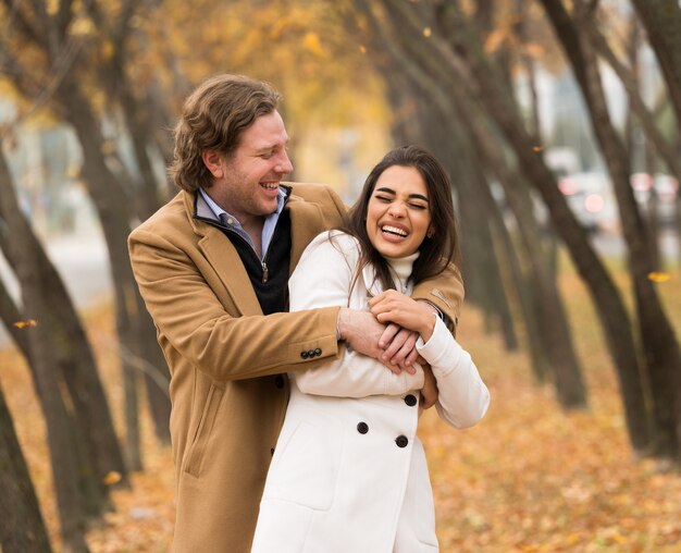 Amorosa pareja caucásica caminando en el parque en otoño