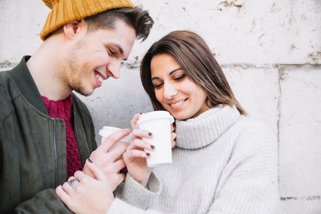 Amorosa pareja disfruta de bebidas en la calle