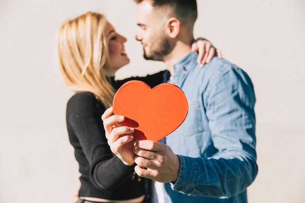 Foto gratuita amorosa pareja feliz mostrando corazón rojo