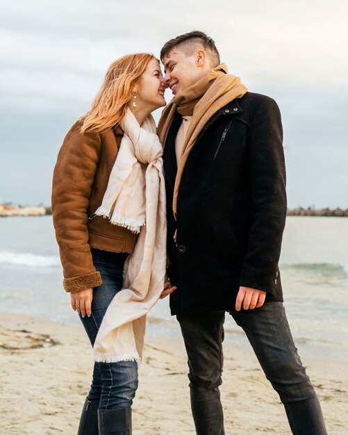 Amorosa pareja joven en invierno en la playa