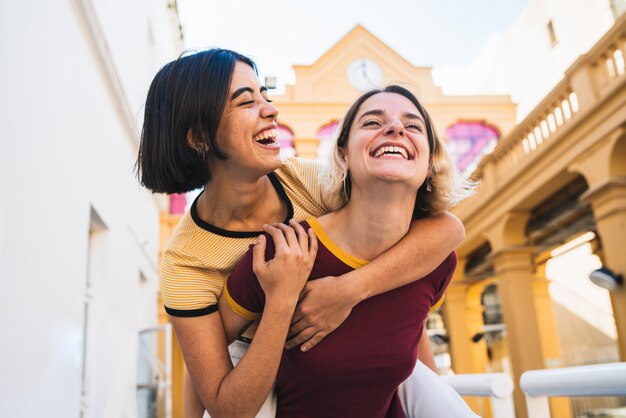 Amorosa pareja de lesbianas divirtiéndose en la calle.