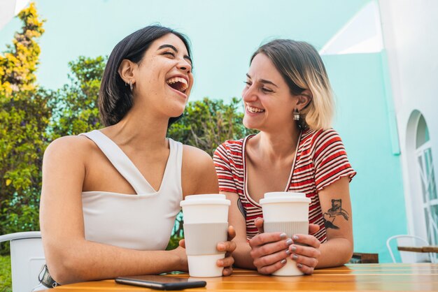 Amorosa pareja de lesbianas tener una cita en la cafetería.