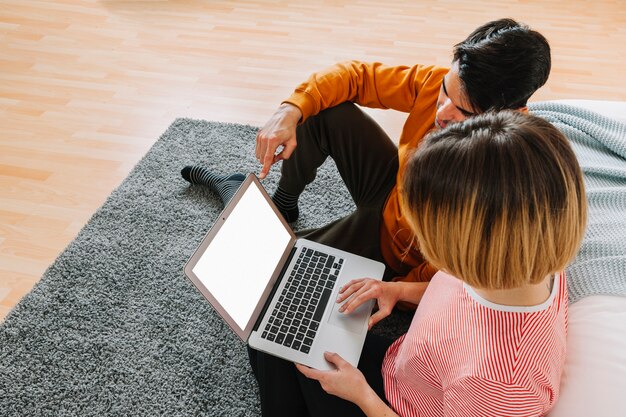 Amorosa pareja usando laptop cerca de la cama