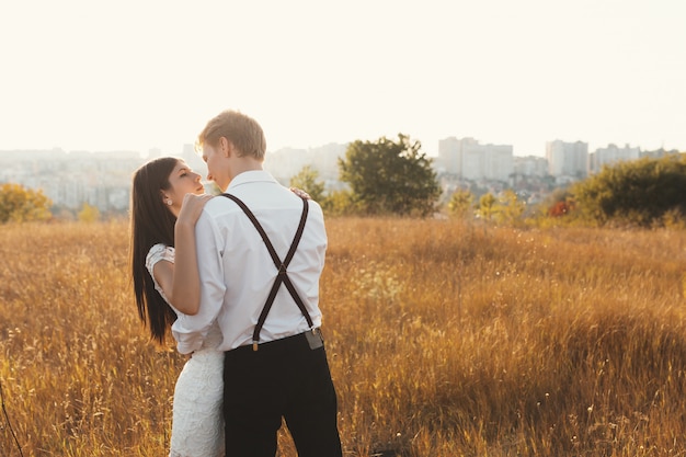 Amorosa pareja vestida de blanco besándose al aire libre