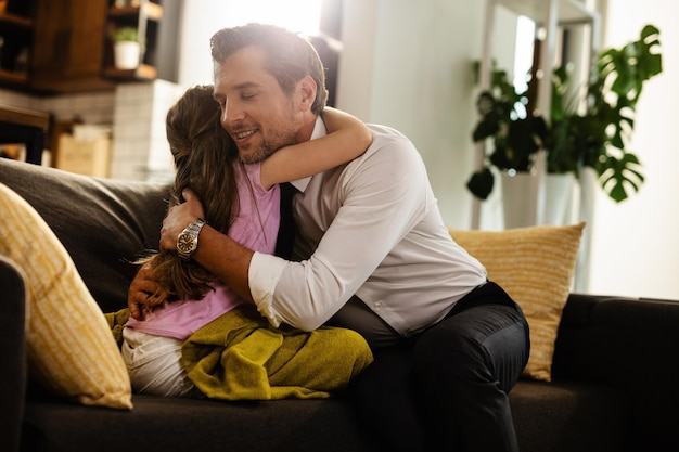 Amoroso padre e hija abrazándose con cariño en la sala de estar