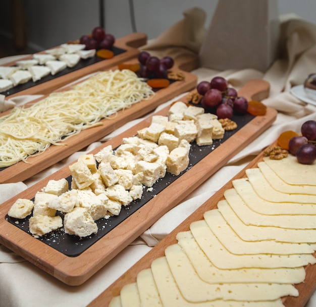 Una amplia selección de platos de queso con uvas frescas sobre la mesa.