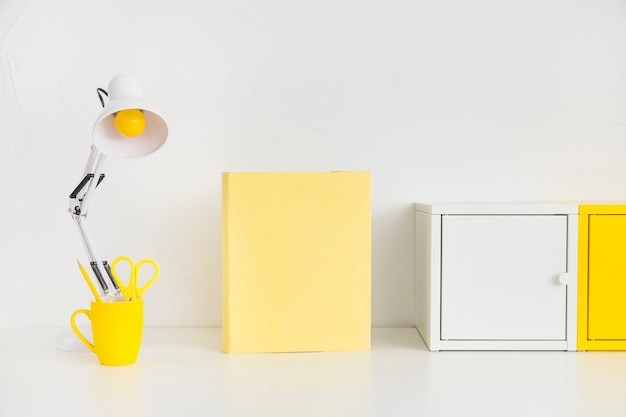 Amplio lugar de trabajo con cajas de metal y cuaderno amarillo