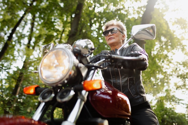 Anciana de ángulo bajo con motocicleta genial