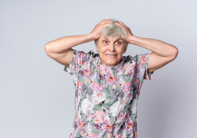 Anciana ansiosa sostiene la cabeza mirando hacia adelante aislado en la pared blanca