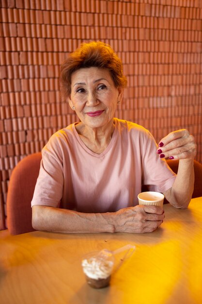 Anciana bebiendo café en una cafetería