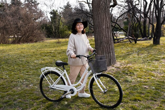 Foto gratuita anciana caminando con su bicicleta