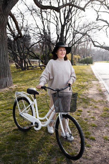 Foto gratuita anciana caminando con su bicicleta