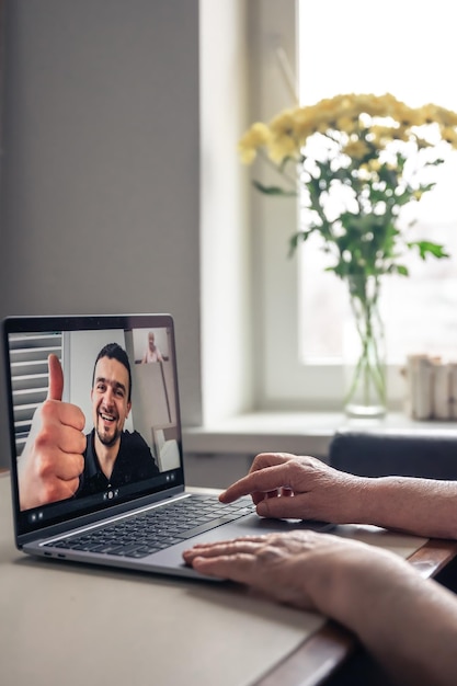 Foto gratuita una anciana se comunica con su hijo a través de un enlace de video a través de una computadora portátil