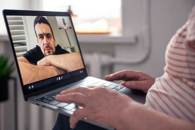 Foto gratuita una anciana se comunica con su hijo a través de un enlace de video a través de una computadora portátil