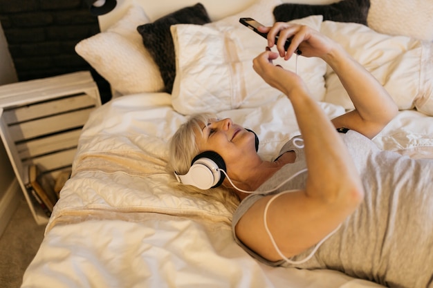 Anciana escuchando música en la cama