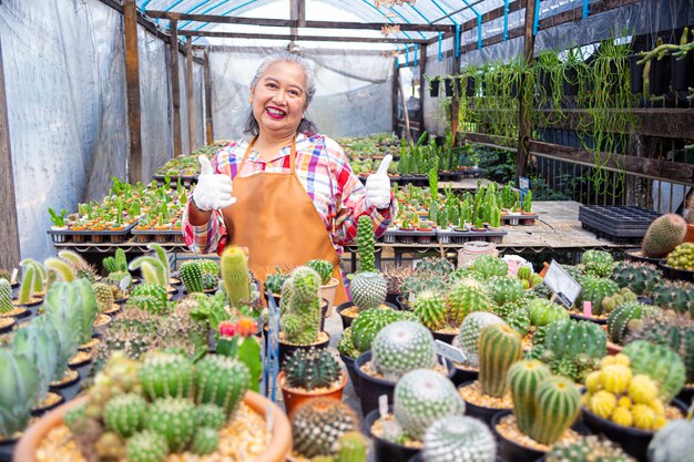 Anciana feliz con una granja de cactus