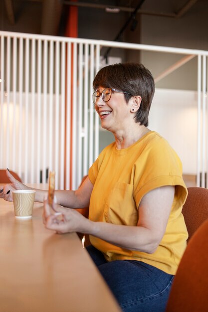 Foto gratuita anciana hablando y bebiendo café