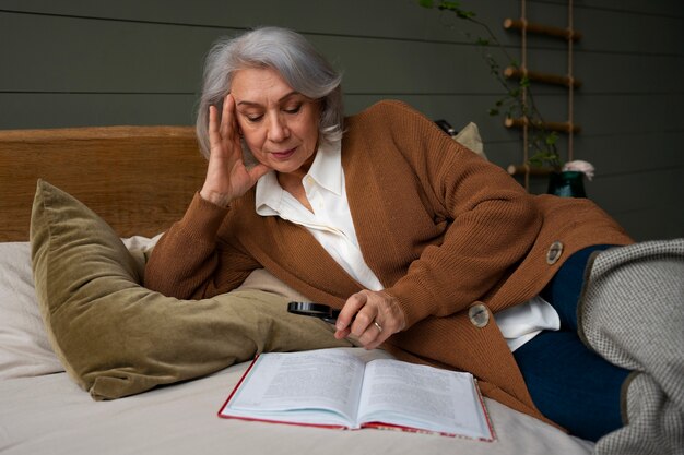 Anciana leyendo mientras usa una lupa