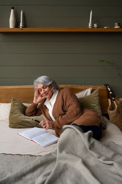Foto gratuita anciana leyendo mientras usa una lupa