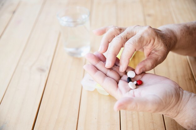 Anciana prepararse para comer píldora de medicina diaria
