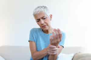 Foto gratuita anciana que sufre de dolor en la mano artritis anciana y anciana que sufre de dolor en casa