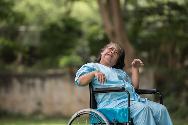 Anciana sentada en silla de ruedas con la enfermedad de Alzheimer