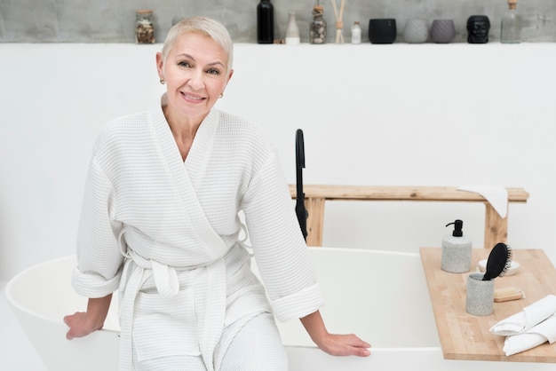 Foto gratuita anciana sonriendo y posando en bata de baño