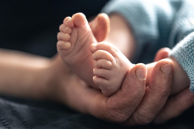 Foto gratuita la anciana sostiene las piernas del niño en sus manos.