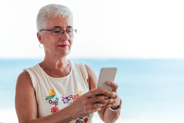 Anciana en el teléfono móvil en casa