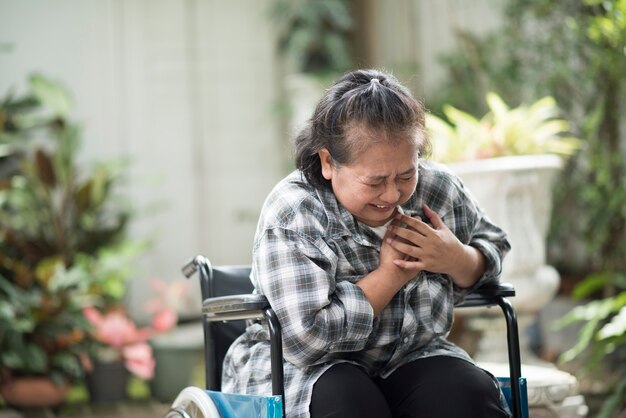 anciana tiene enfermedad cardíaca sentado en silla de ruedas