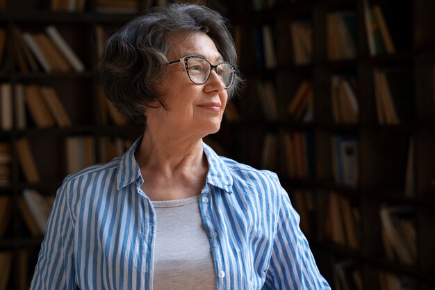 Anciana de tiro medio en la biblioteca