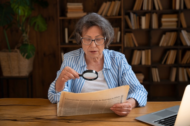 Anciana de tiro medio en la biblioteca