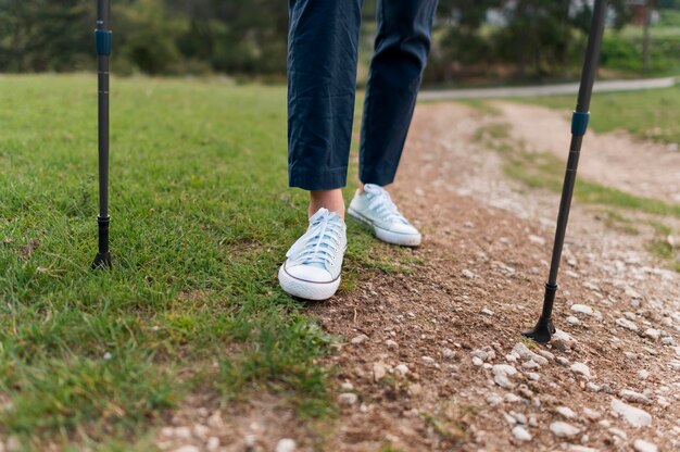 Anciana turista caminando con bastones de senderismo