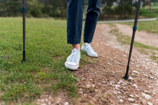 Anciana turista caminando con bastones de senderismo