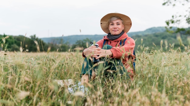 Anciana turista en naturaleza y pasto