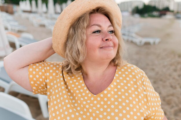 Anciana turista posando en la playa