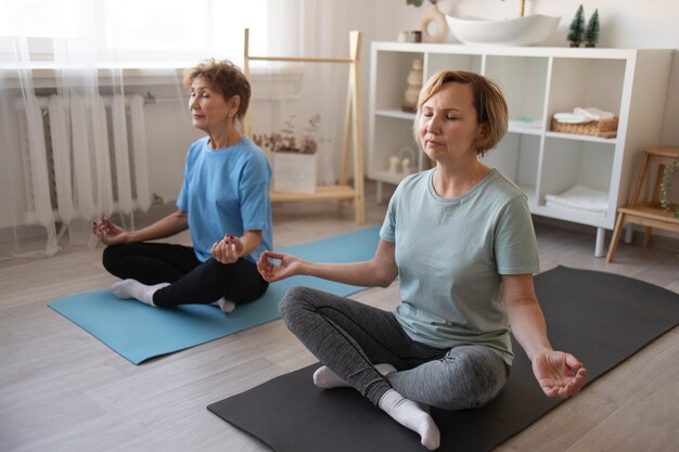 Ancianas haciendo yoga y pasando tiempo juntas