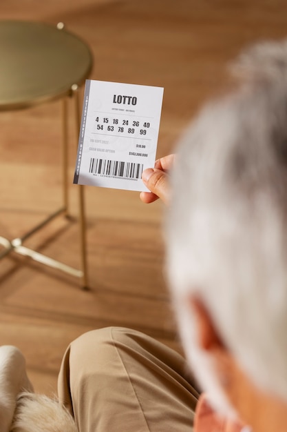 Foto gratuita anciano de alto ángulo con boleto de lotería