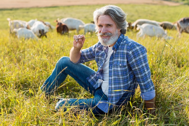 Foto gratuita anciano de alto ángulo con cabras en la granja