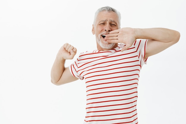 Anciano bostezo que se extiende después de una buena siesta