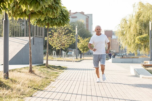 Anciano corriendo en la acera