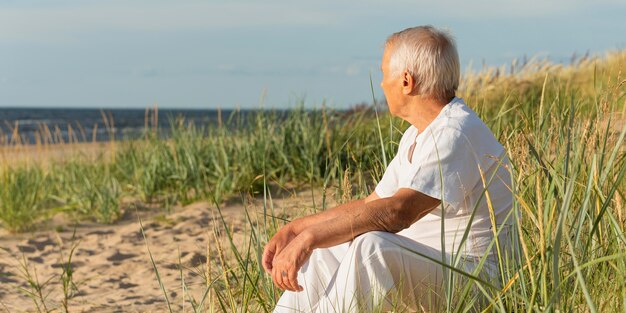 Anciano descansando en la playa y disfrutando de la vista